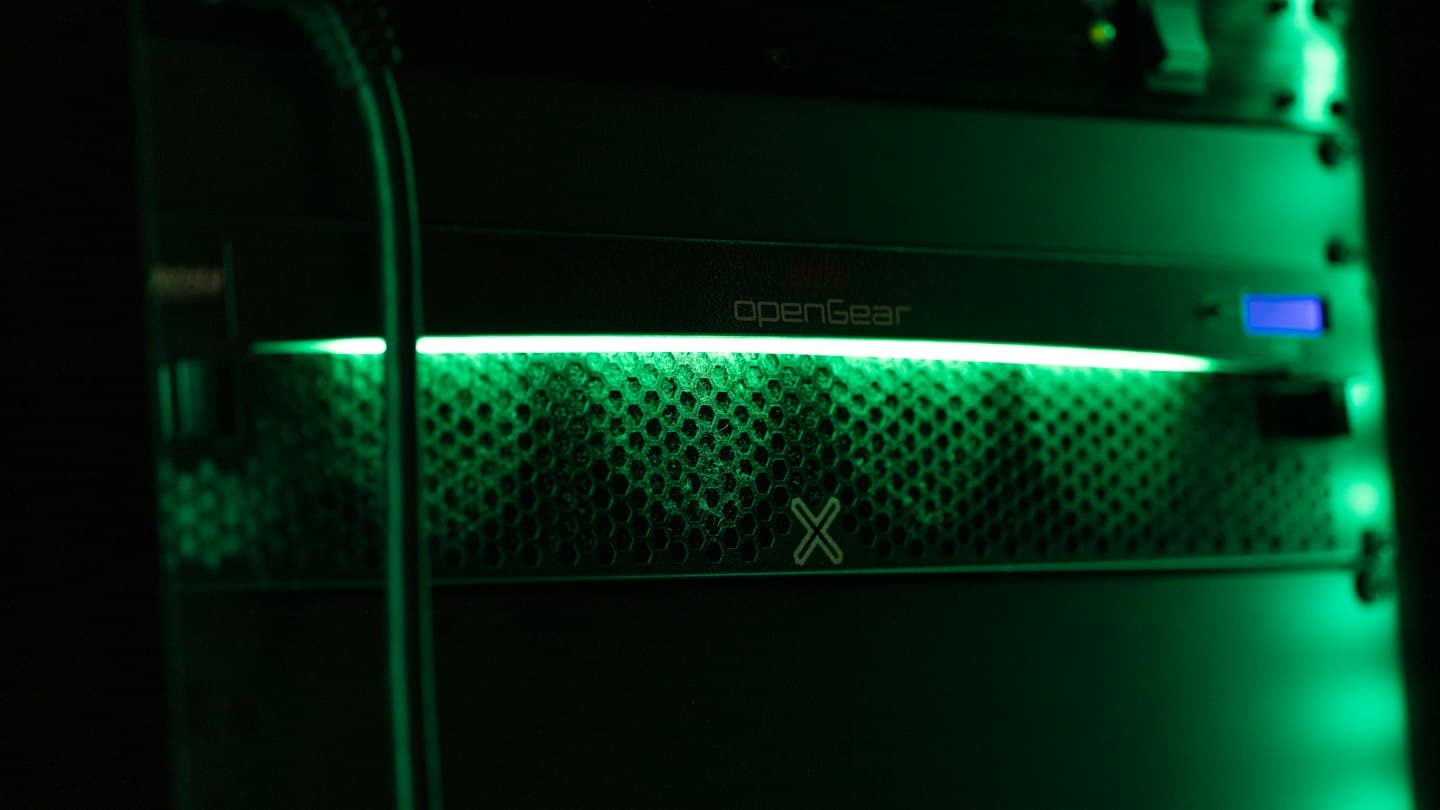 Black server rack equipment with a green glowing light strip.